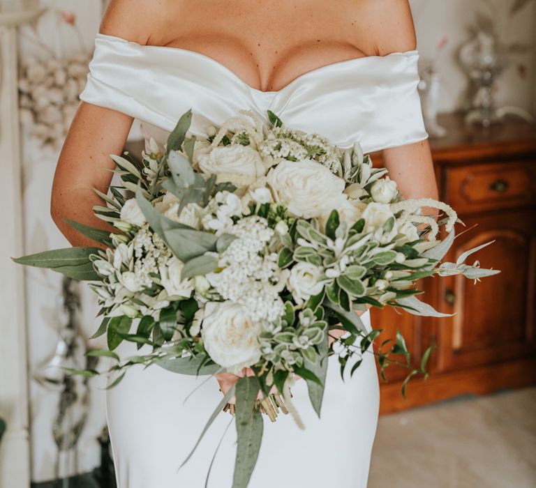 Bridal bun with veil and white wedding bouquet for bride