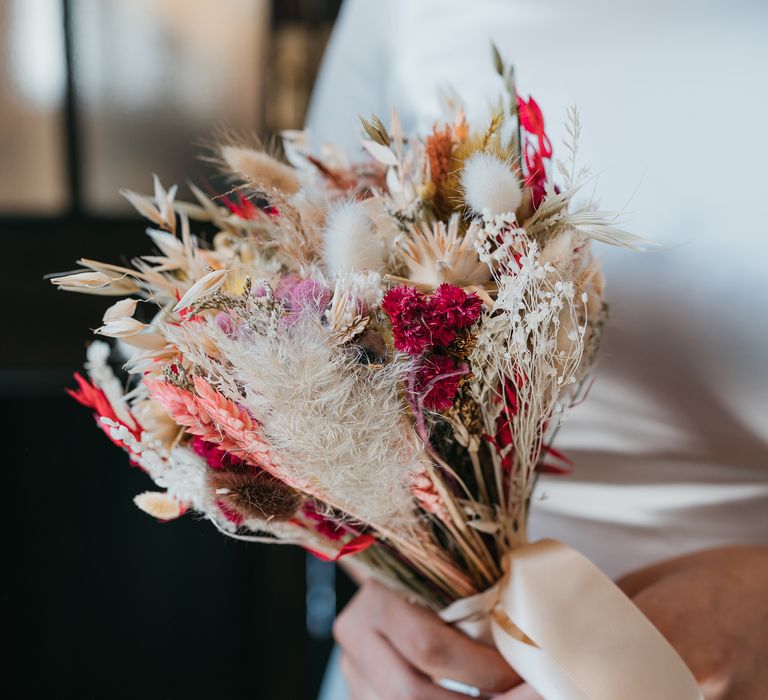 Small dried flower bouquet with vibrant colours tied with white silk ribbon