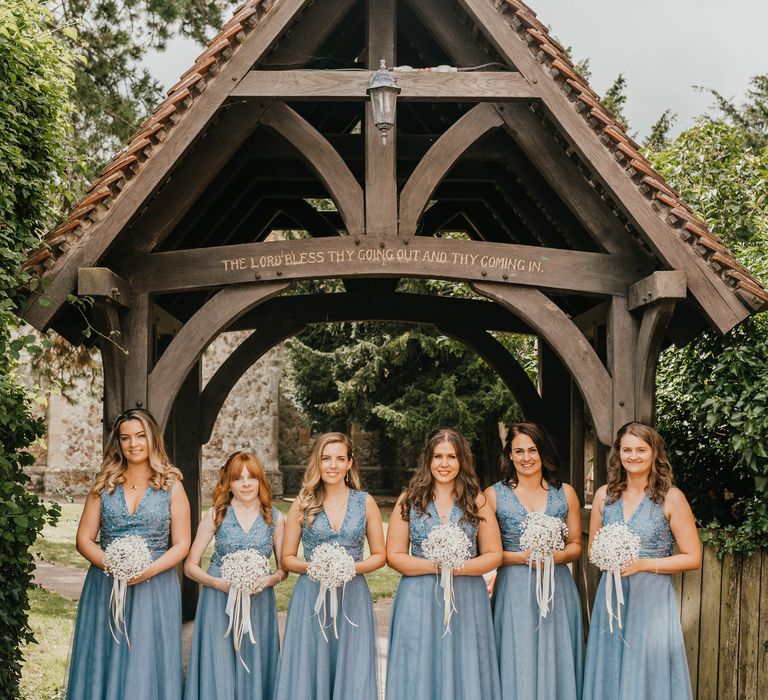 Bridesmaids wear pale blue bridesmaids dresses outside church