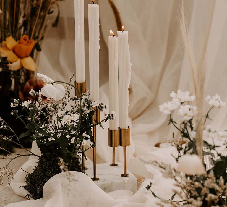 Marble and brass candlestick holder with white taper candles 