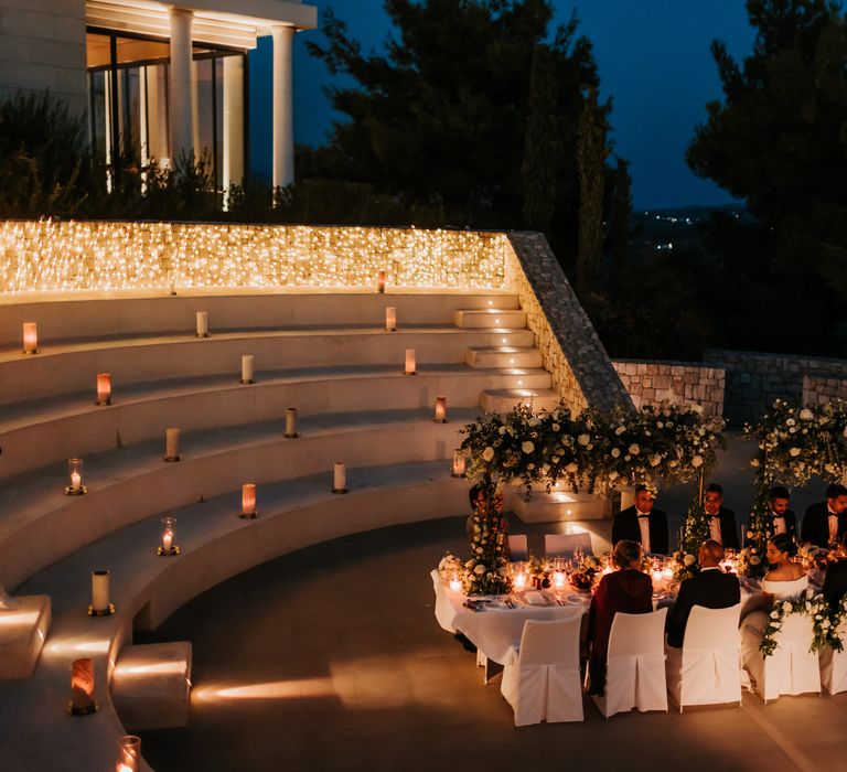 Beautifully lit reception dinner complete with fairy lights and floral installations in amphitheatre  | Hannah MacGregor Photo & Film