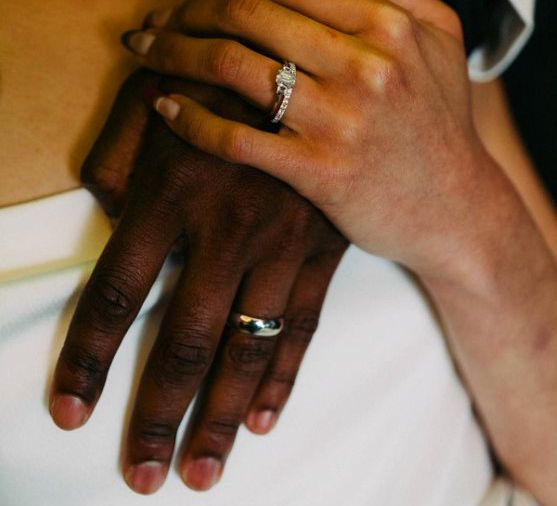 Bride covers her hand across grooms hand on her wedding day  | W Hotel Rock N Roll Bride Magazine