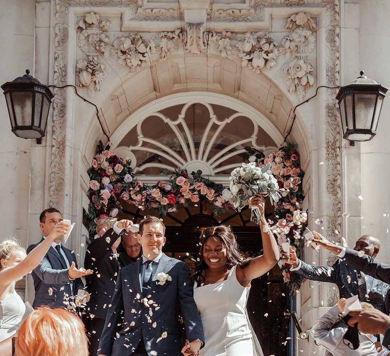 Bride & groom leave Chelsea Old Town Hall on their wedding day as confetti is thrown around them