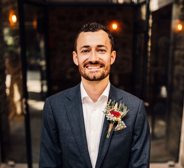 Groom smiles and poses for camera on his wedding day