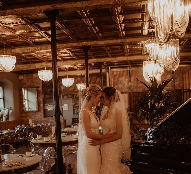 Brides kiss in rustic wedding venue setting