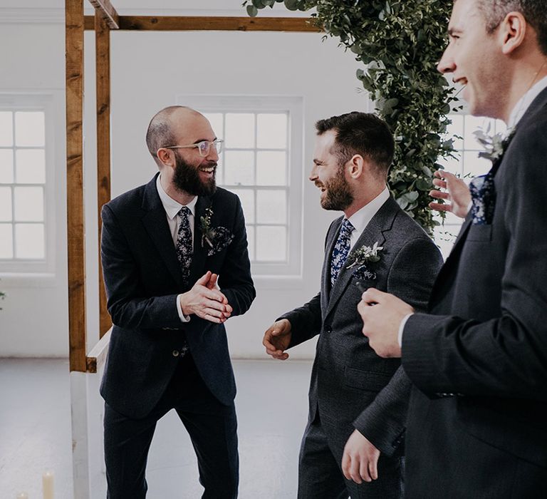 Groom stands with groomsman on his wedding day