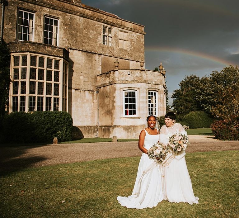 Two brides at LGBTQI+ wedding with rainbow shining 