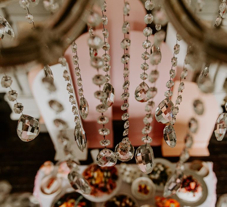 crystal chandelier hanging over the food table at retro wedding 