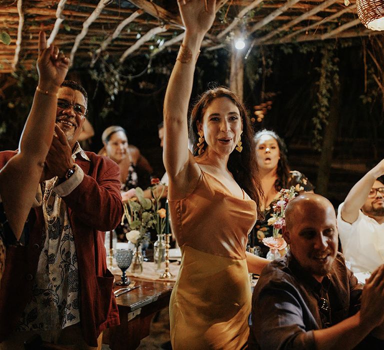 Wedding guests applaud as the bride and groom enter the reception at outdoor destination wedding