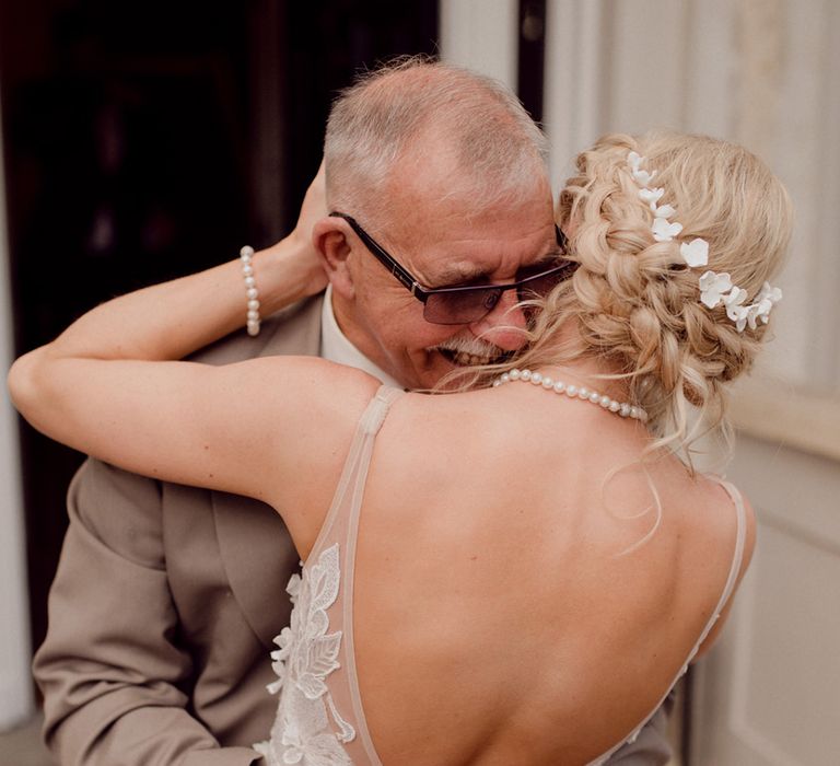 Bride in 3D Made With Love Bridal wedding dress wearing pearl necklace and bracelet hugs wedding guest