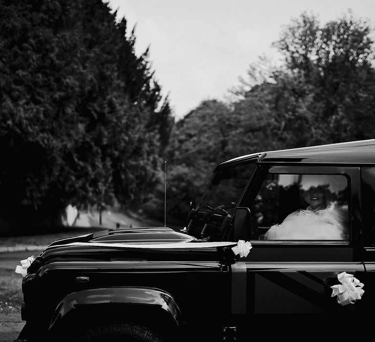 Black wedding car decorated with white ribbon 