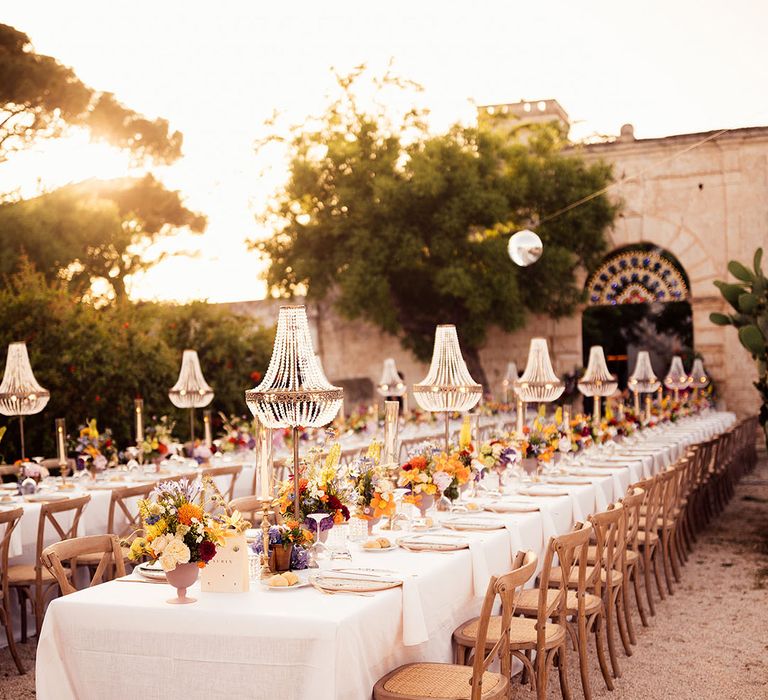 Romantic wedding tablescape with chandelier installation and colourful wedding flower arrangements