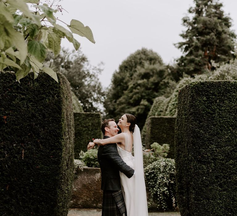 Cute couple portrait of the bride and groom on their wedding day at Pimhill Barn with the groom lifting her up 