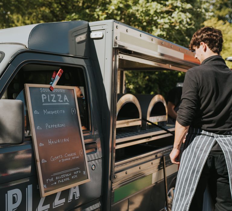 Large black wedding food truck serving wedding pizza in the garden of The Reid Rooms wedding venue