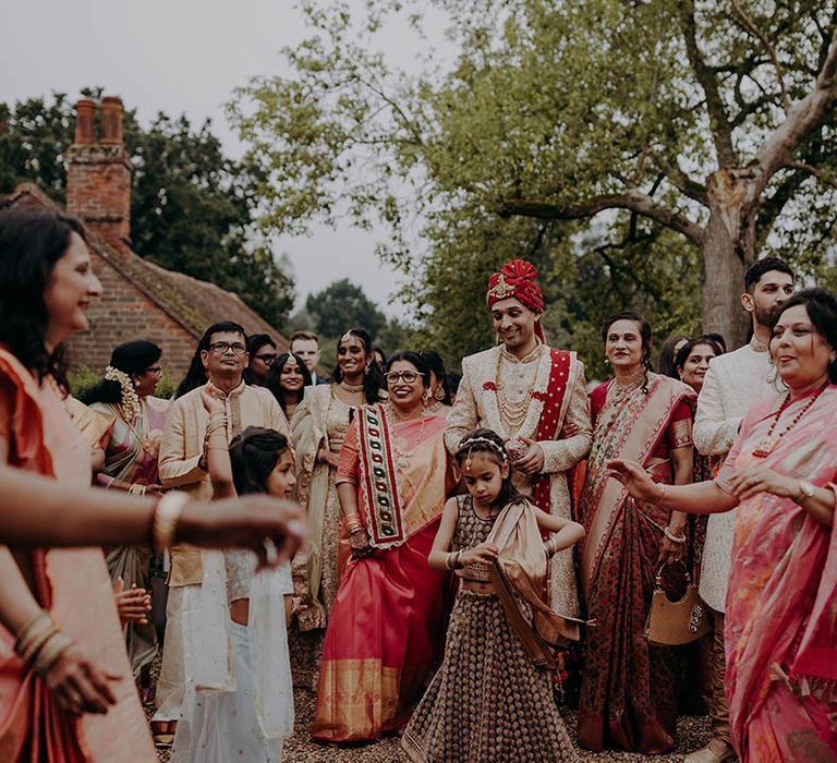 Wedding guests in colourful outfits gather outdoors to dance for Hindu and Sri Lankan wedding 