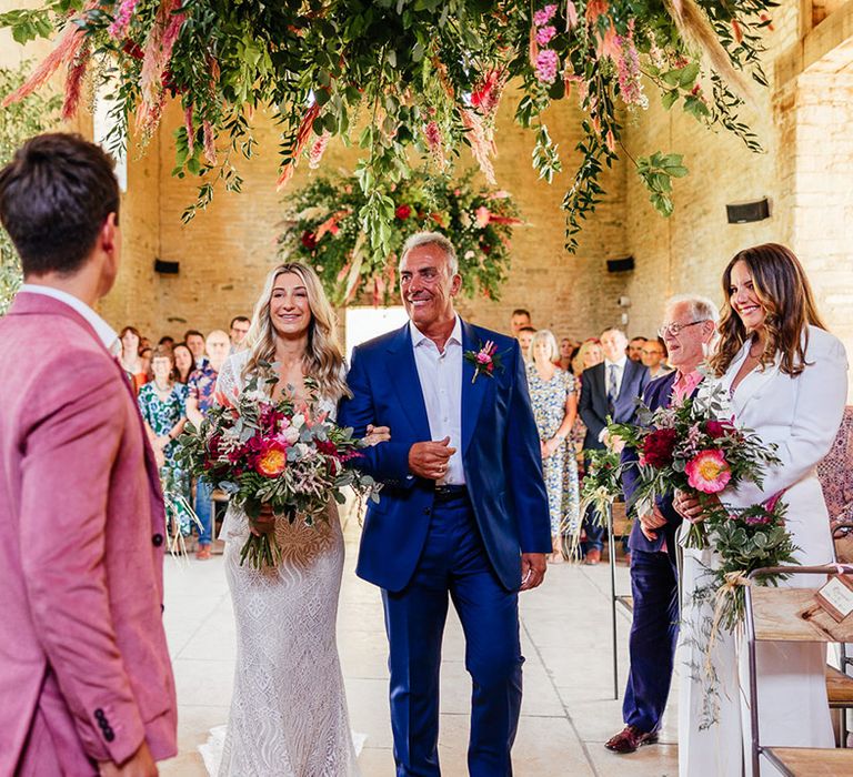 Bride in boho lace long sleeve wedding dress walking down the aisle with father in Klein blue suit 