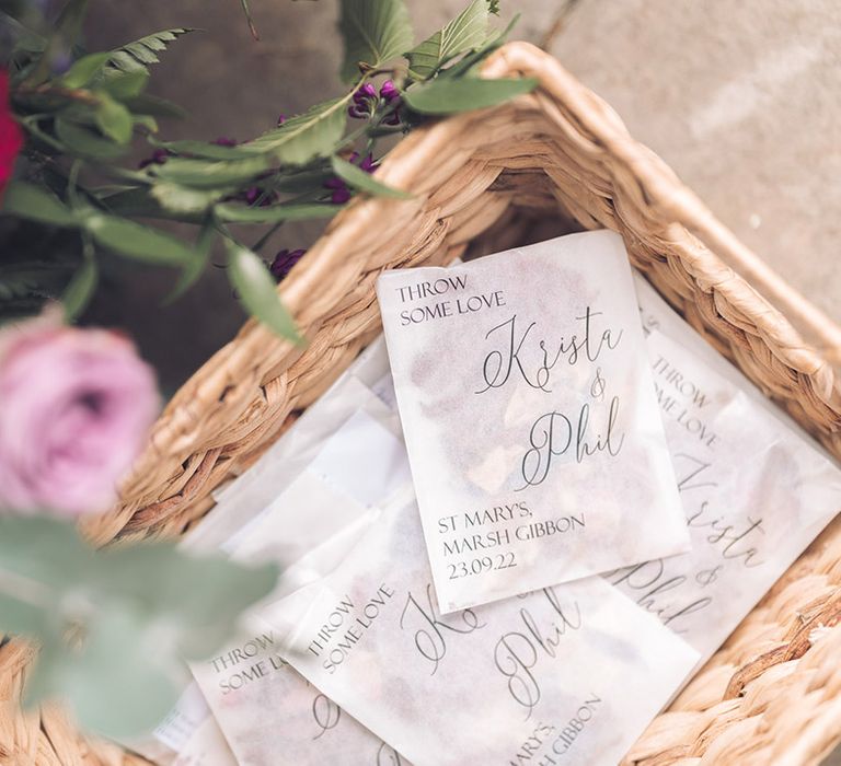 Wedding confetti in personalised pouches in wicker baskets with the wedding date and couple's name 