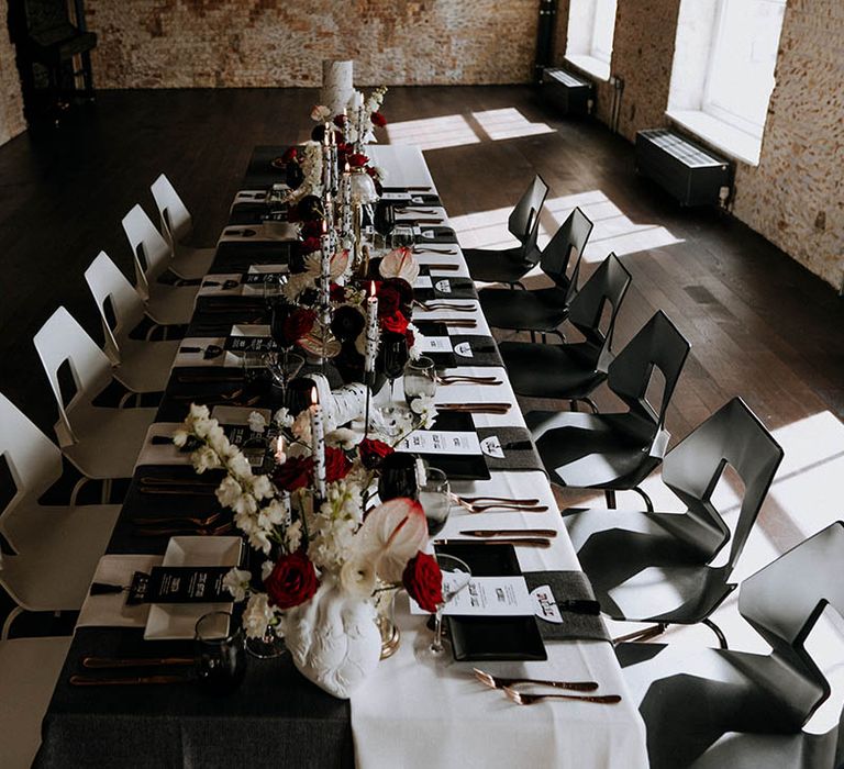 Contemporary and monochrome wedding tablescape with black red and white wedding decor, chairs, centrepieces and accessories 