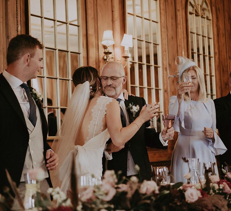 Bride hugs her father during wedding reception at Hedsor House with classic styling