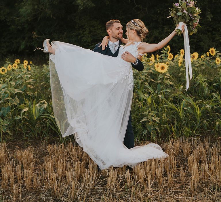 Dove Barn Weddings with the groom lifting the bride so she doesn't ruin her silver sparkly Jimmy Choo wedding shoes 