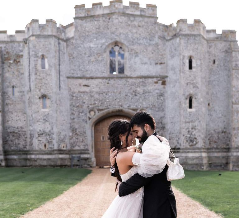 Bride and groom embracing outside of Pentney Abbey wedding venue at modern fairytale styled wedding shoot 