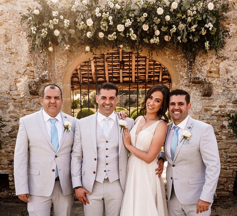 bride in a sparkly wedding dress and groomsmen in light blue check suits at Cotswolds wedding