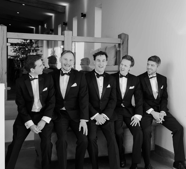 Black and white group shot of the groom and groomsmen in tuxedos at Upton barn wedding venue