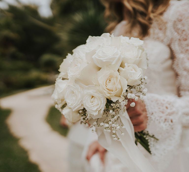 white roses and bride holding a gypsophila wedding bouquet