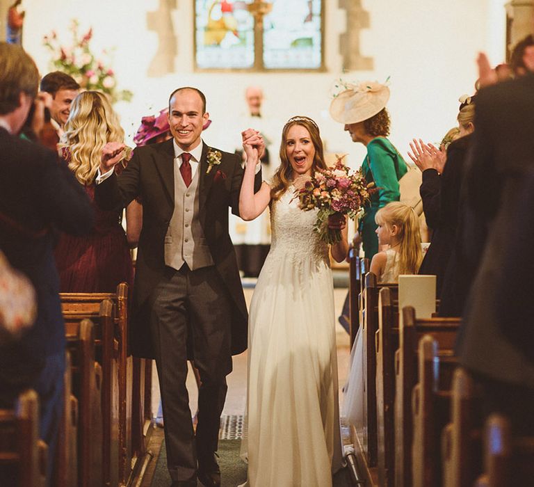 The bride and groom walk back down the aisle at their Surrey church wedding 