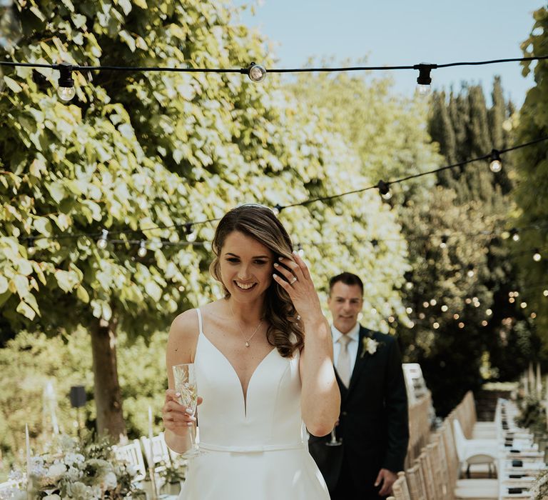 Bride and groom walking around their wedding reception outdoors 