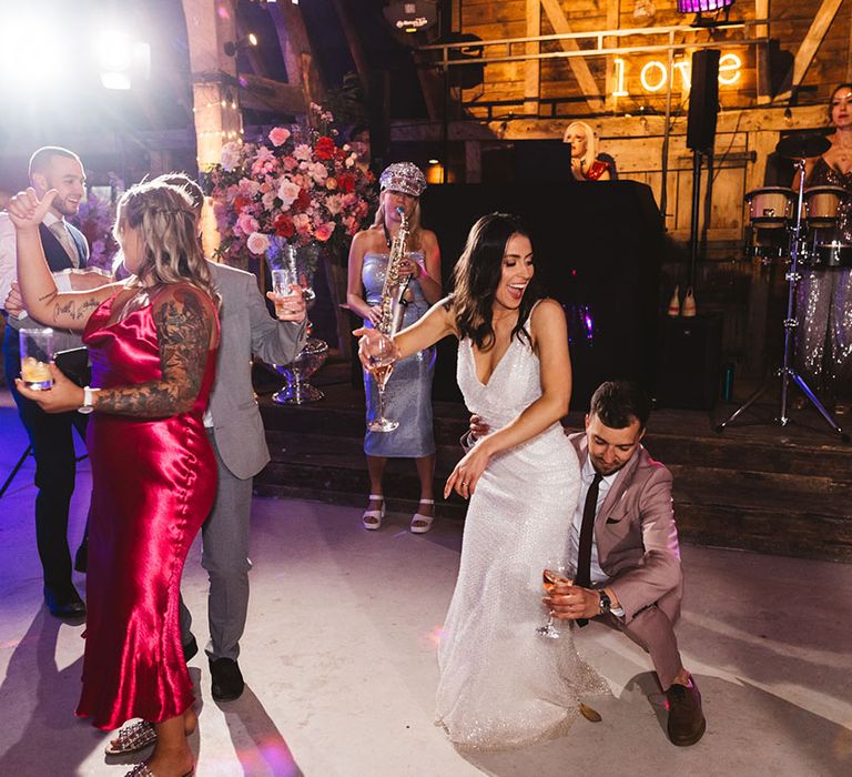 Bride and groom dancing at their reception with a saxophone player 