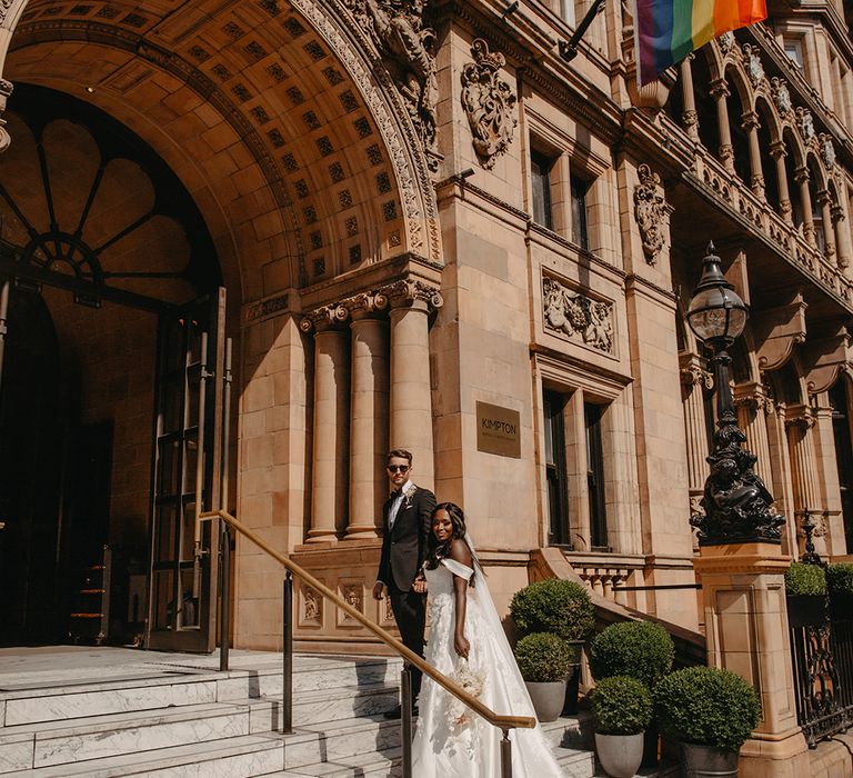 Bride and groom walking up the steps to Kimpton Fitzroy London wedding venue 