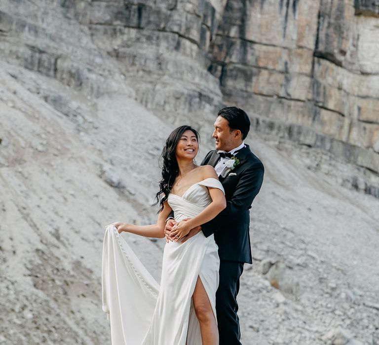 The groom embraces the bride for their couple photos 