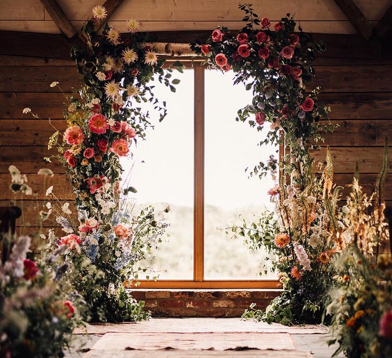 Botanical wedding decor with flower columns lining the altar 