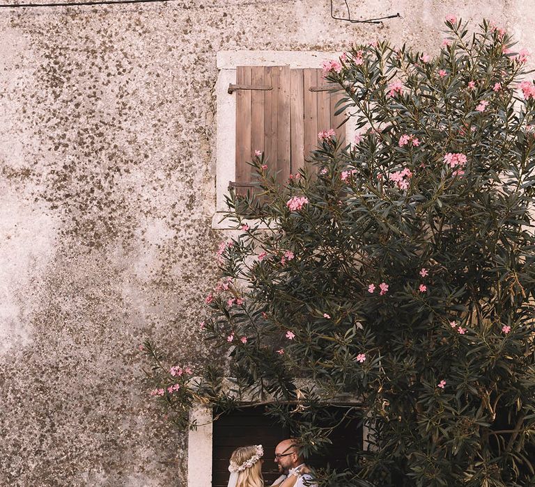 Bride in boho gown with groom in relaxed shirt and tie 