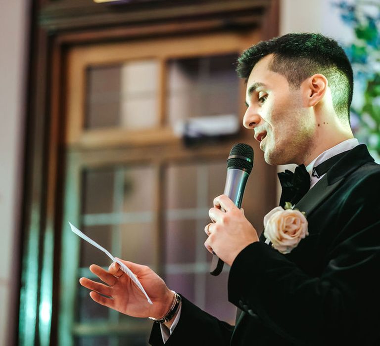 Groom stands to read out the wedding speech 