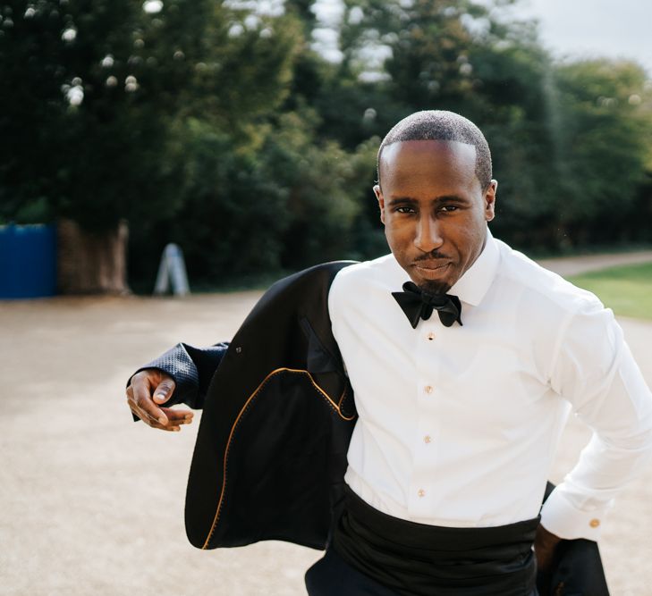 Groom in navy tuxedo and bow tie 