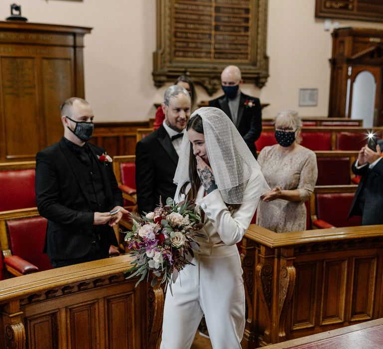 Bride in jumpsuit entering the wedding ceremony at Brighton micro wedding 