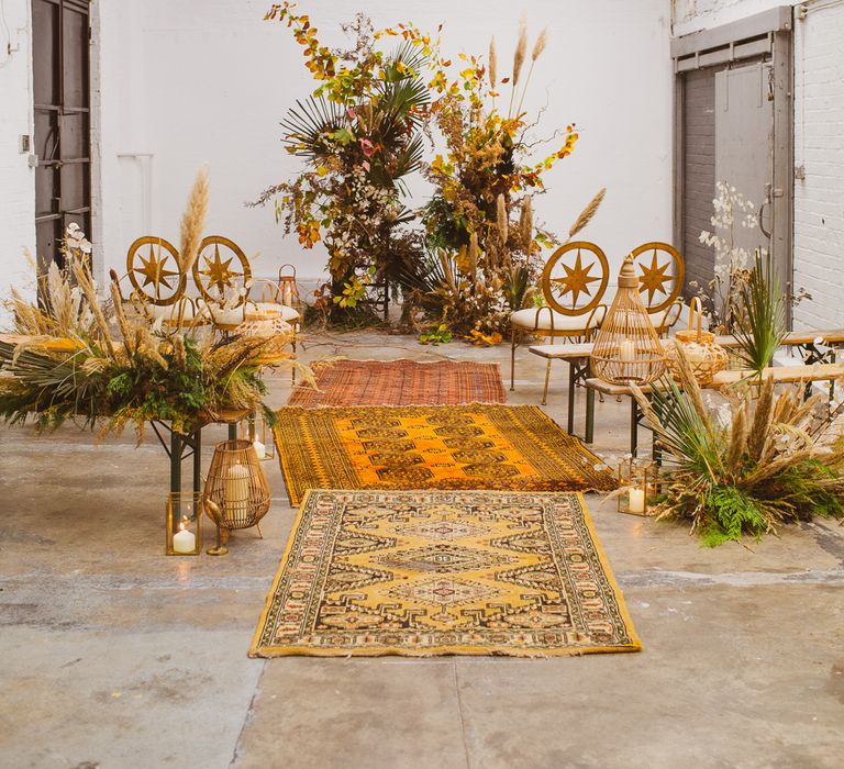 Earthy wedding ideas for the aisle of a sustainable wedding with Persian rugs and pampas grass