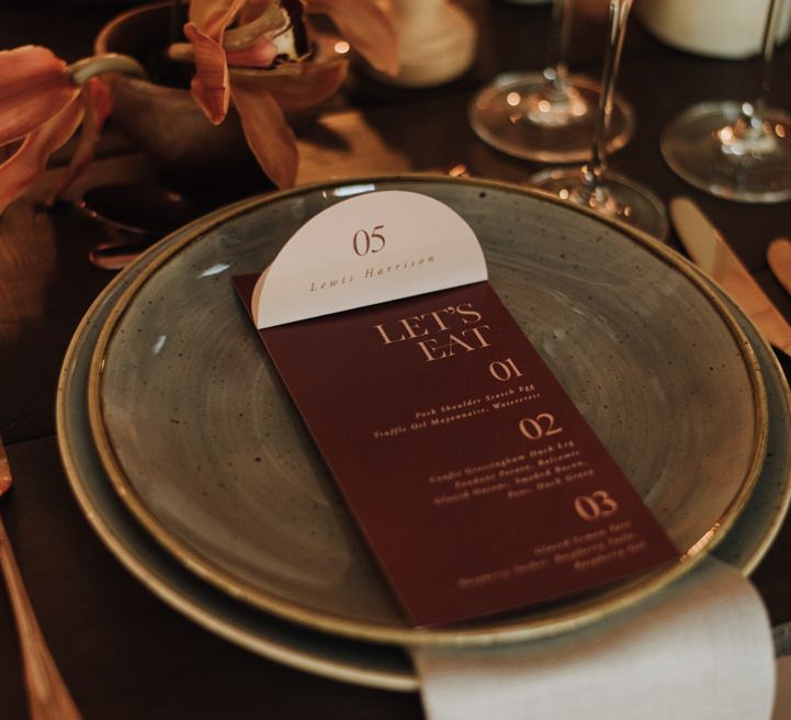 Soft blue linen place setting for wedding with dark menu details