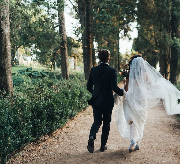 Bride and groom portrait with the groom holding his brides wedding veil