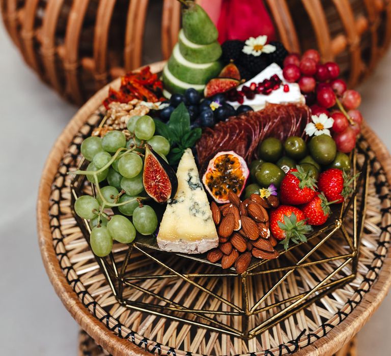 Colourful grazing platter on top of wooden weaved table