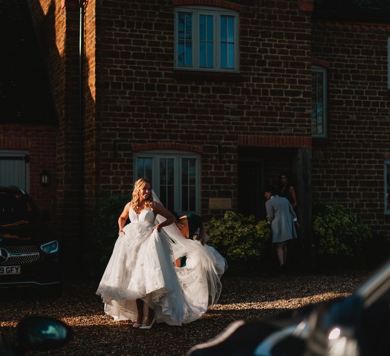 Bride walks in the sunlight to the car