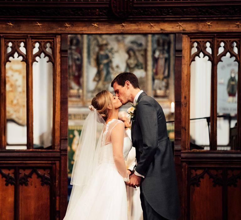 Bride & groom kiss during wedding ceremony