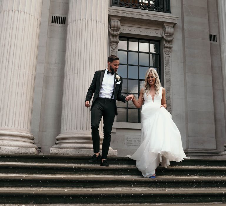 Bride & groom walk down the steps of Marylebone Town Hall