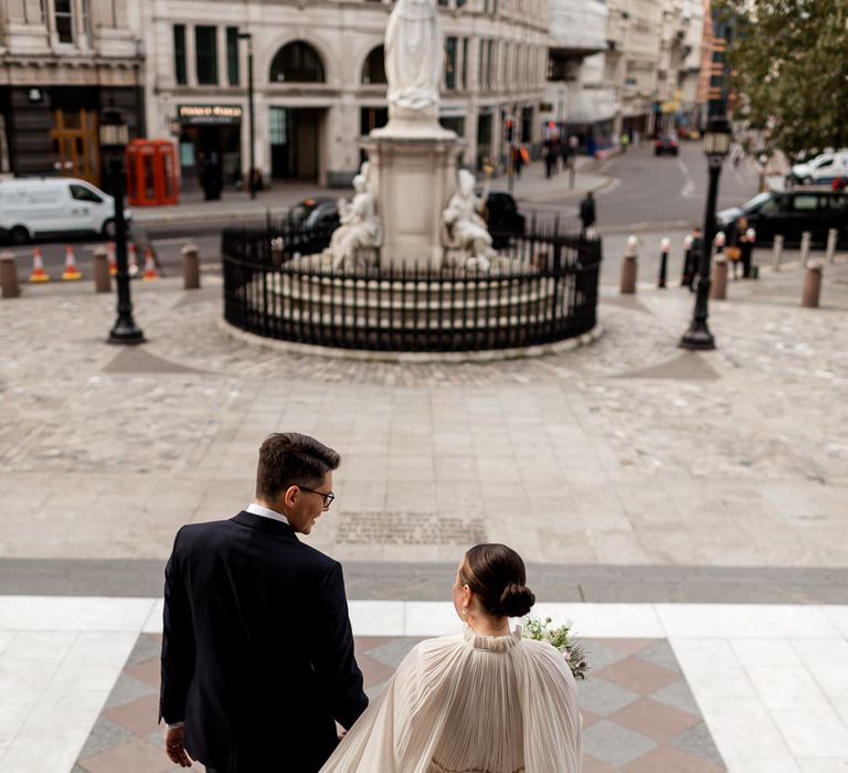 Bride in a pleated Lanvin wedding dress with long sleeves and ruffle hem 