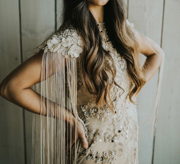 Embellished wedding dress with appliqué flower detail on the shoulder and tassels 