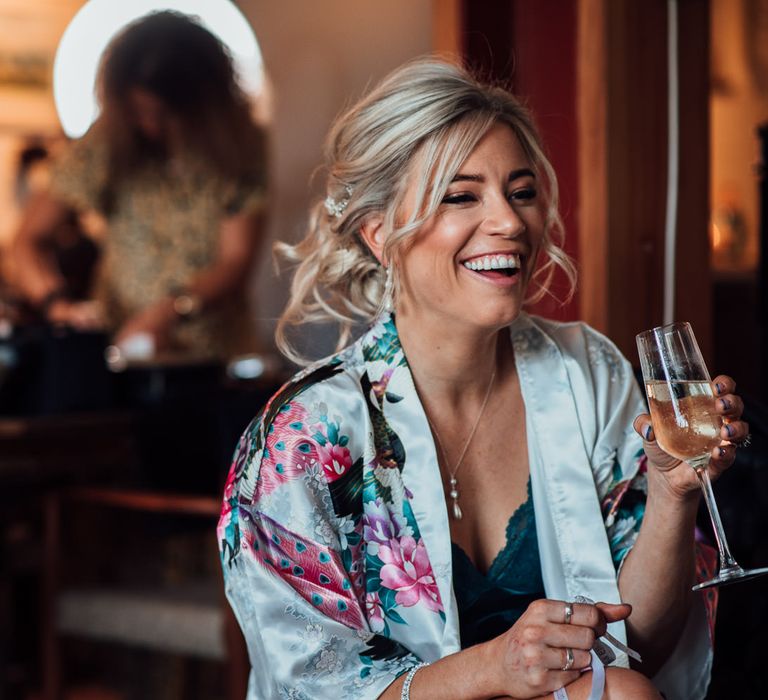 Bride has her makeup done and laughs on the morning of her wedding