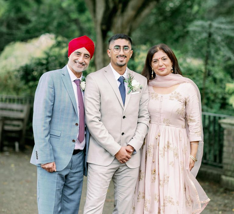 Sikh groom with his parents at interfaith wedding 