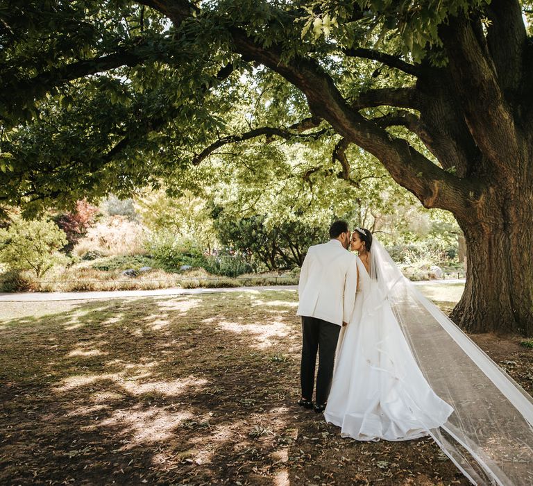 Bride and groom portrait under a tree for a classic black tie wedding with Ethiopian traditions 